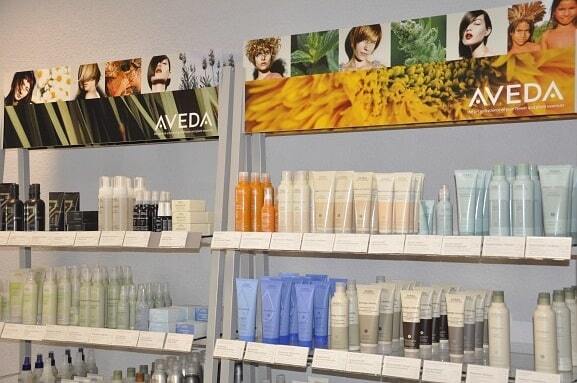 Regale mit verschiedenen Aveda Haarpflegeprodukten und Kosmetik im Friseursalon.